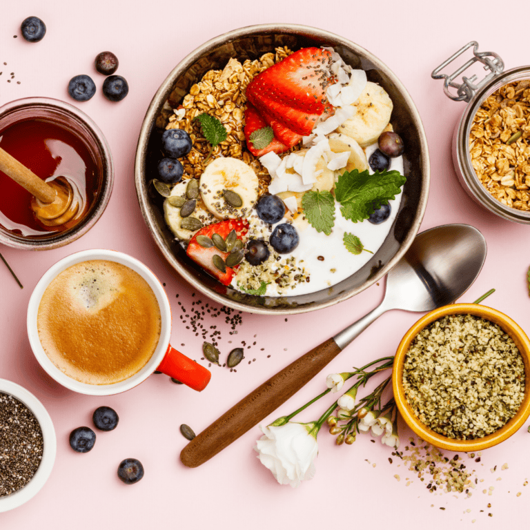 bowl of yogurt with toppings and bowls of granola, chia seeds, and honey around it