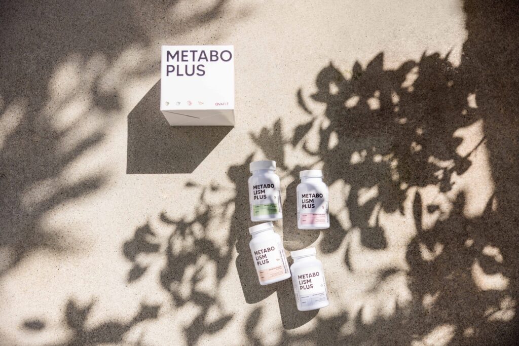 Metabolism plus box and individual bottles on concrete with shadow of trees overlaying them