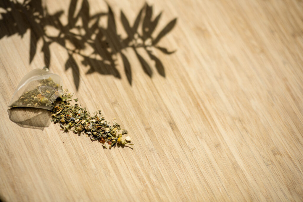 Tea bag with different herbs spilled on a table