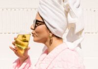 tallene in her robe and towel on her head sipping from a glass of testosterone relief tea