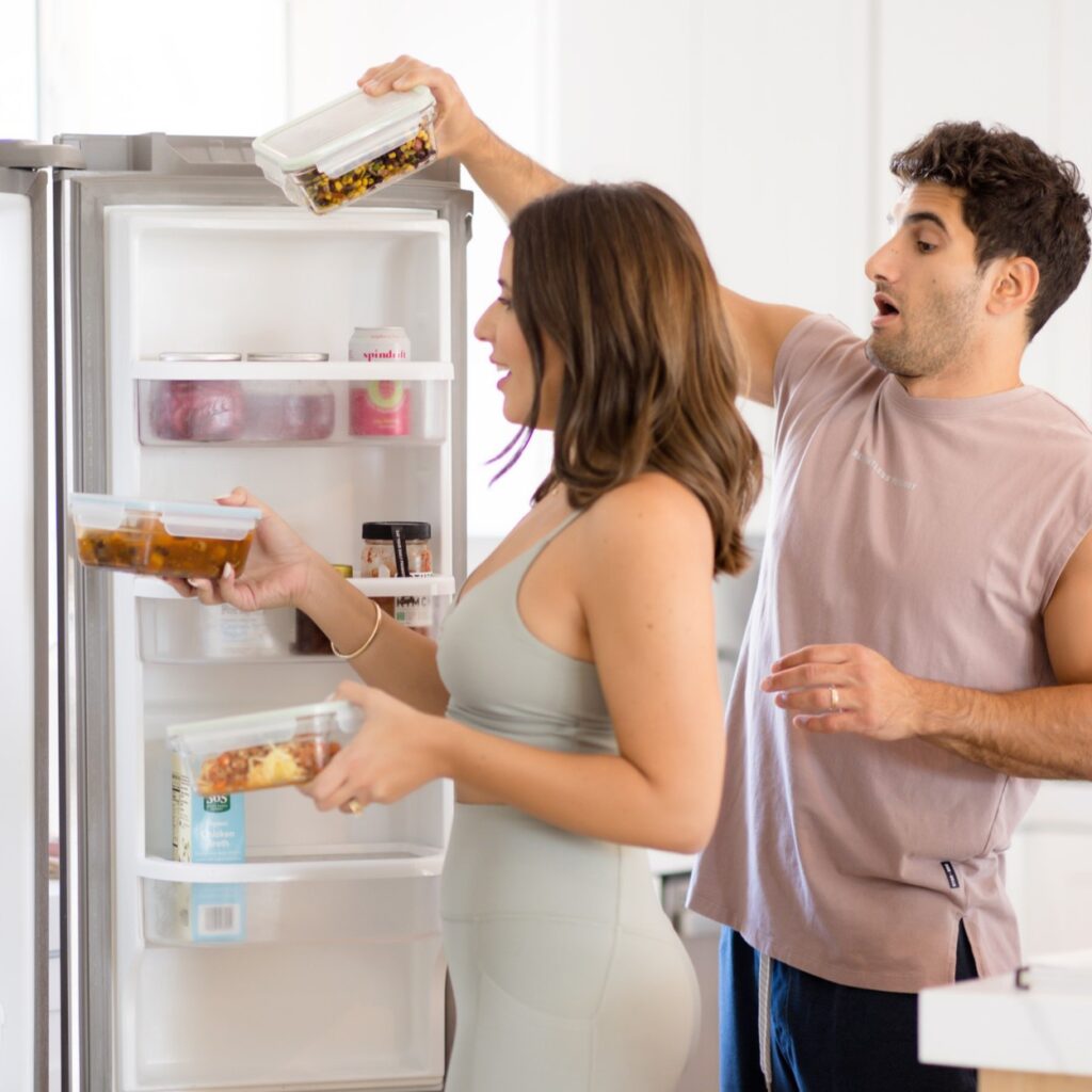 Tallene and Sirak placing food containers into the fridge