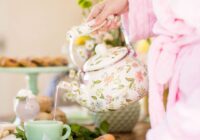 hand holding a teapot being poured into a teacup