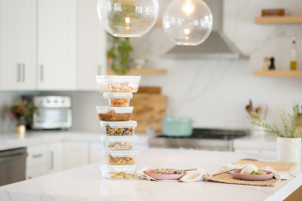 Meal prep containers with all different meals stacked 7 containers high on a counter