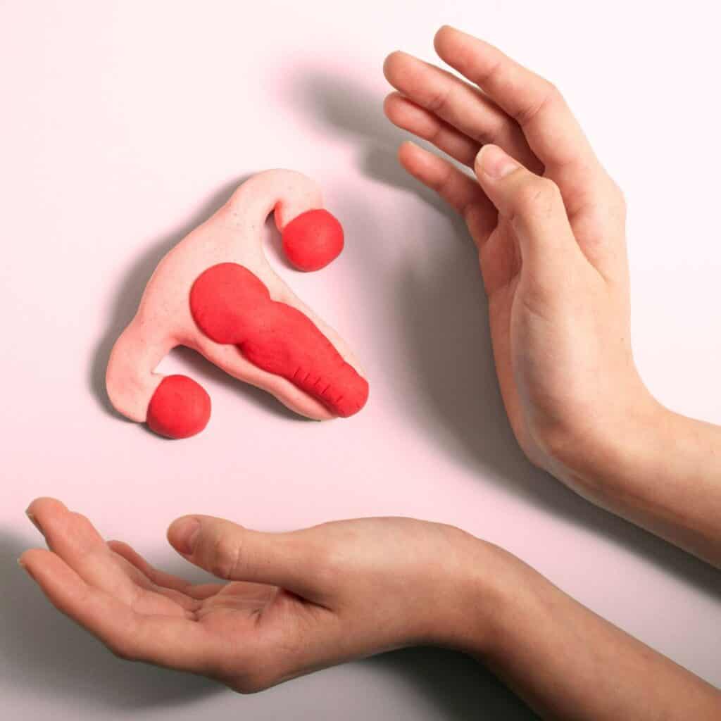 clay depiction of a uterus Woman's hand cradling a clay depiction of a uterus.