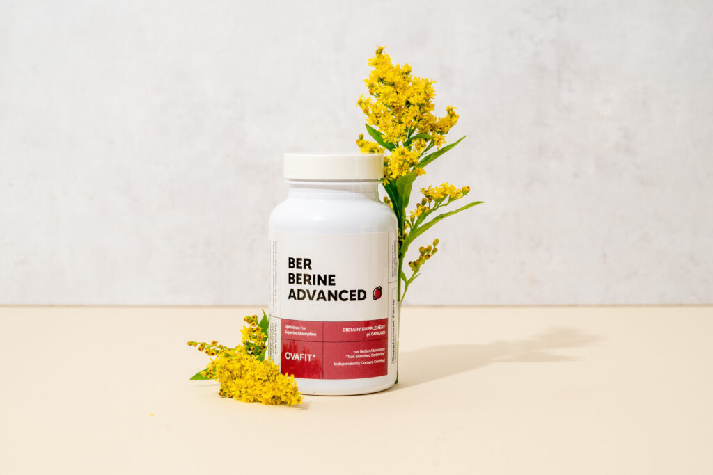 Berberine supplement bottle in with two golden flowers next to it