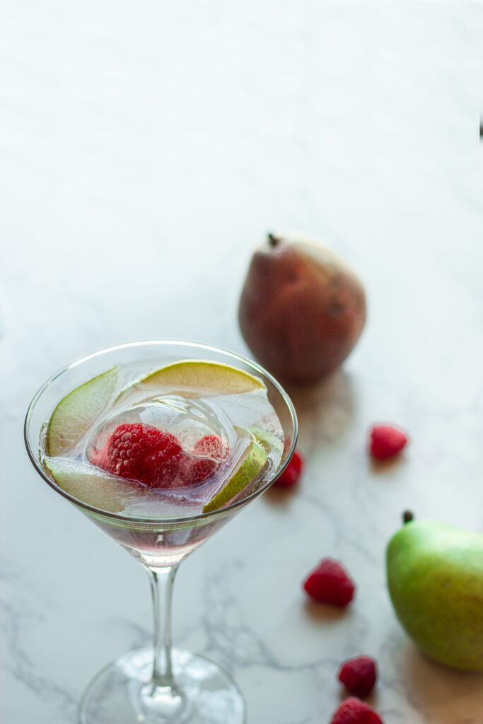 mocktail in a martini glass mocktail in a martini glass with pear slices and raspberries
