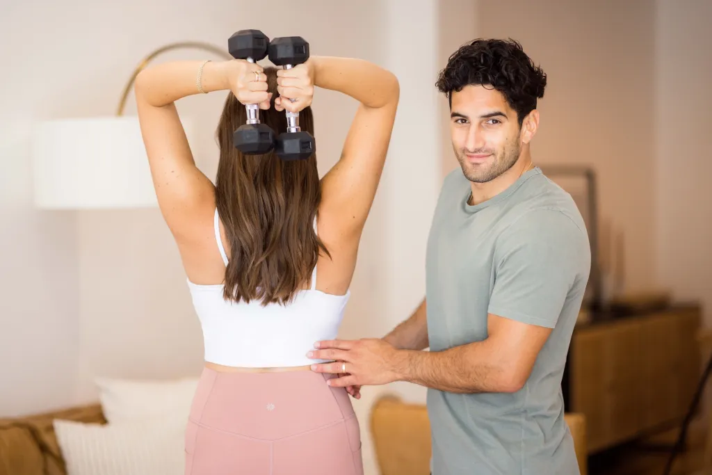 Sirak and Tallene standing with weights