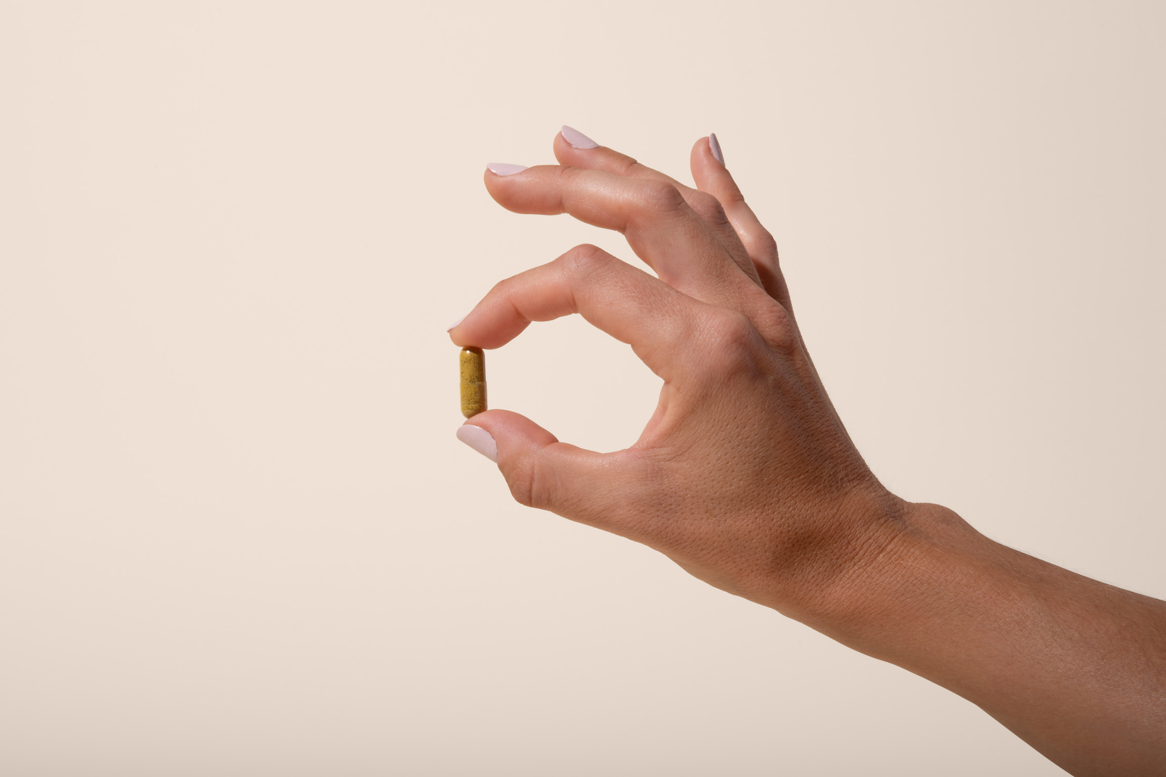 hand holding a capsule